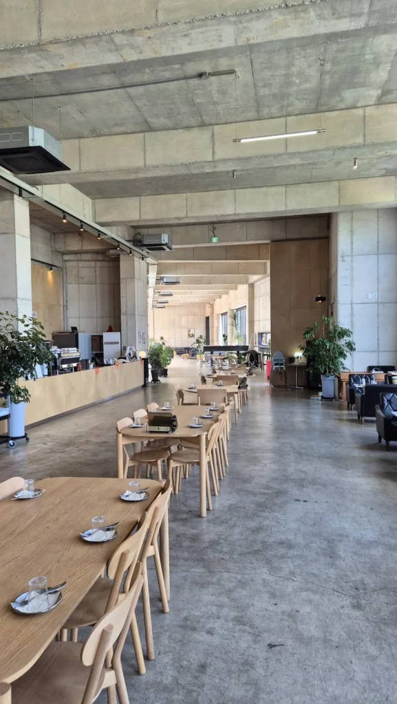 Long communal wooden tables in the airy concrete hall of La Montagna cafe