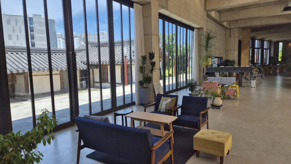 Concrete interior of La Montagna cafe with designer furniture and a hanok courtyard view in Gangneung
